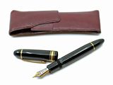 un stylo et un étui en cuir posés sur une surface blanche