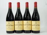 quatre bouteilles de vin sont alignées sur une surface blanche