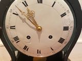 a black and gold clock on a wooden table