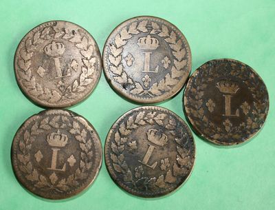 four different types of coins sitting on top of a green surface
