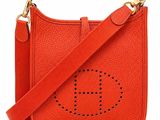 a red cross body bag with the letter h on it
