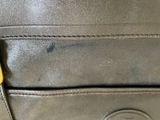 the back of a black purse with a yellow tag on it