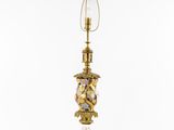 a gold lamp with a glass shade on top of it