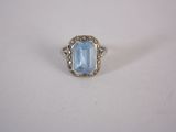 a close up of a ring with a blue stone in it