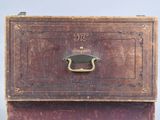 an old wooden box with a handle on top of it