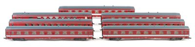 four red and gray train cars sitting next to each other on a white surface