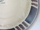 a white bowl with black and brown designs on it