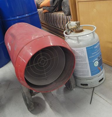 a man sitting on a couch next to a stack of barrels