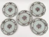 quatre assiettes ornées de motifs floraux, posées sur une surface blanche