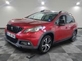 une voiture rouge garée dans un garage au sol en damier