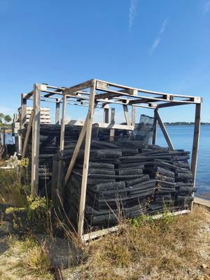 a pile of tires sitting on the beach next to the water