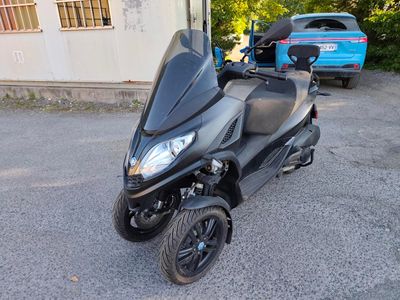 un scooter garé sur un parking à côté d'un immeuble