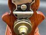 a small wooden clock with a metal face on it