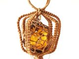 un sac entouré d'une corde, contenant une balle jaune, posé sur une surface blanche
