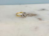 a close up of a gold and diamond ring on a marble surface