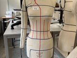 a mannequin on a stand in a sewing room