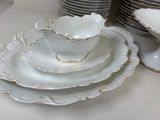 a lot of white plates and bowls on the table