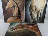 trois tableaux représentant des chevaux sont exposés sur un fond blanc