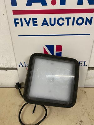 un gros plan d'une lampe posée au sol près d'un panneau