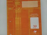 un cahier orange sur lequel est inscrit un numéro, posé sur une table
