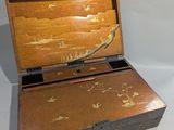 a small wooden box with a lid that has a design on it