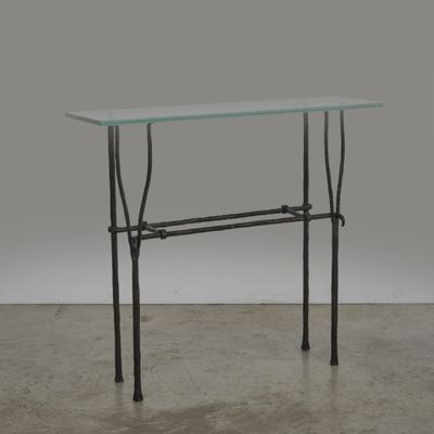 une table en verre avec un cadre en métal et un plateau en verre