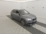 the bmw x1 is parked in a garage with a checkered floor