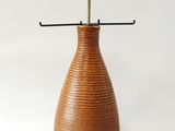 un vase marron avec une anse noire sur fond blanc