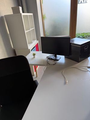 un bureau équipé d'un écran d'ordinateur et d'une imprimante