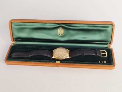 une photo d'une montre dans un coffret, avec un bracelet en cuir