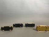 three miniature black and gold train cars sitting on a gray surface