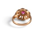 a close up of a gold ring with a pink stone