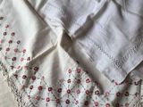 a white table cloth with red flowers on it