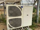 un gros climatiseur posé au milieu d'un champ