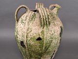 un vase vert et blanc posé sur une surface grise