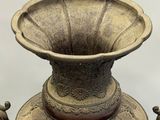 a bronze vase that is sitting on a table