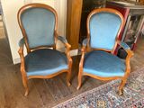 pair of blue upholstered chairs in a room with a rug