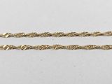 a pair of gold chains on a white surface