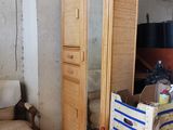 une pièce avec une chaise, un miroir, une chaise et une armoire
