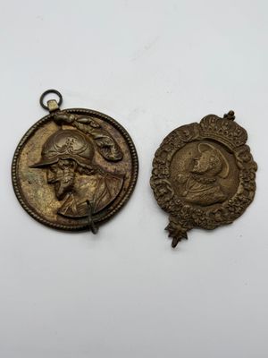 two bronze medallions of a man and a woman