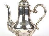 théière plaquée argent, ornée d'un motif décoratif sur un socle, sur fond blanc