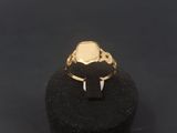 a gold signet ring with a black stone in the middle