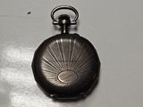 a small silver pocket watch on a white surface