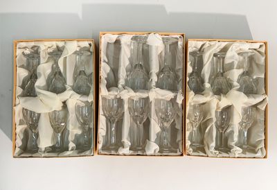 three boxes of glass figurines sitting on a table