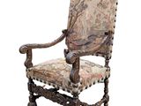 an old chair with a floral upholstered back and arms