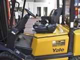a yellow forklift truck parked on the side of the street