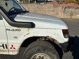 un camion blanc garé sur le bord de la route
