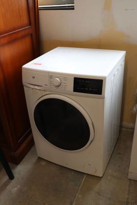 a white washer and dryer in a small room