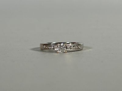 a close up of a diamond ring on a white surface