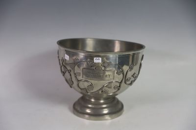 a silver bowl with a design on it on a white surface